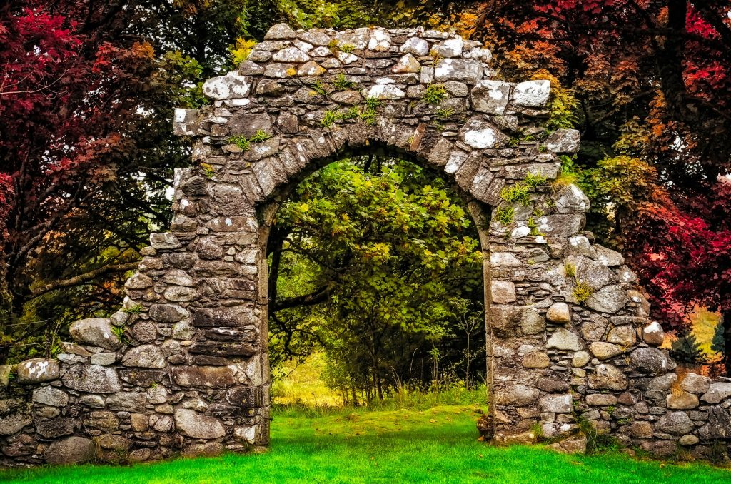 Old stone entrance wall in the garden with colorful foliage Old stone entrance wall in the garden with colorful foliage